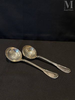 deux cuillères en argent posées sur une table noire