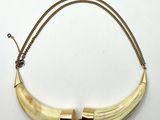 gros plan d'un collier sur une surface blanche avec une chaîne