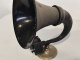 an old black and silver horn sitting on top of a white table