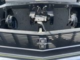 le capot d'une voiture, ouvert, dont le moteur se trouve à l'arrière