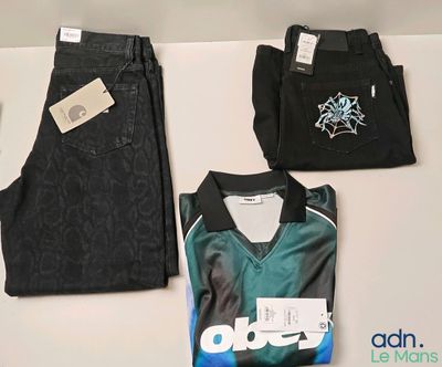 trois paires de vêtements pour homme exposées sur une table