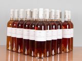 six bottles of wine are lined up on a wooden table