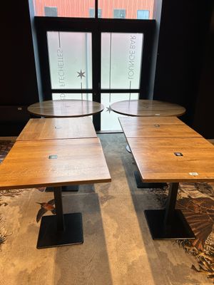 Deux tables en bois sont posées devant une fenêtre dans une pièce.