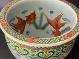 a colorful bowl with two fish in it on a table