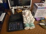 many rolls of toilet paper, a keyboard, and a monitor on a desk