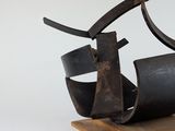 sculpture of a pair of scissors on a wooden stand