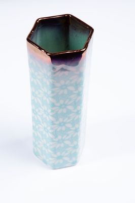 un vase bleu et blanc posé sur une surface blanche