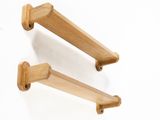 two wooden hooks on a white wall with a white background