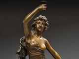 a bronze statue of a woman holding a bird