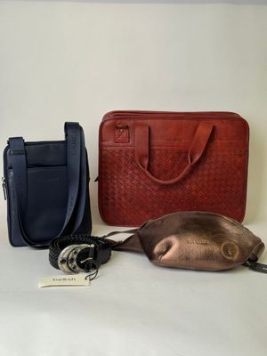 two bags and a purse sitting on a table