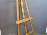 a wooden easel that is standing up against a wall