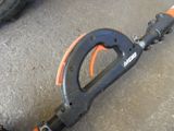 a black and orange scooter on the ground next to a pair of shoes