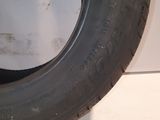 a close up of a tire on the ground with a white wall in the background