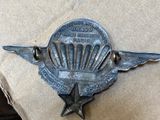 a picture of a small metal emblem on a cardboard box