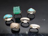 several different rings are arranged on a table with a black background