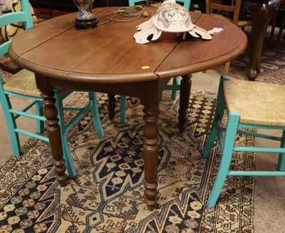 une table en bois avec quatre chaises et un vase posé dessus