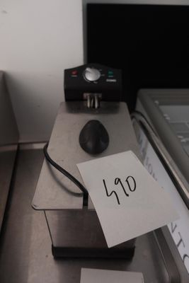 un ordinateur portable posé sur un bureau, avec une note accrochée dessus