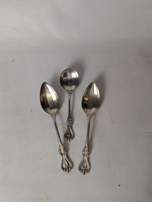 three spoons and a spoon rest on a white surface