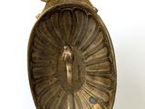 a gold plate with a bird on it on a stand