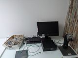 a desk with a monitor, keyboard, mouse, and other electronics on it