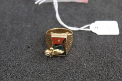 a gold ring with a red and green stone on it