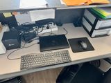 un bureau d'ordinateur sur lequel se trouvent un clavier, une souris et d'autres objets