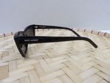 sunglasses on a woven basket with a white wall in the background