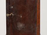 an old wooden cabinet sitting on top of a table next to a white wall