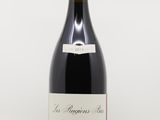 une bouteille de vin rouge posée sur une table blanche