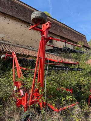 a red tractor that is parked in front of a building
