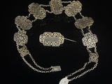 an image of a silver bracelet and broochet set on a black background