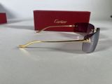 cartier sunglasses in gold and purple with a box on the table
