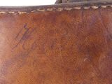 a close up of a brown leather bag with a name on it
