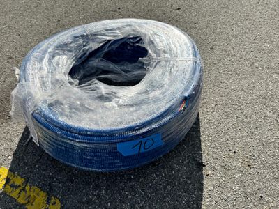 un tuyau bleu posé par terre à côté d'une ligne jaune