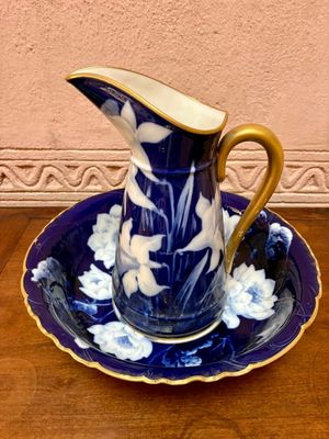 un pichet bleu et blanc et une assiette posés sur une table