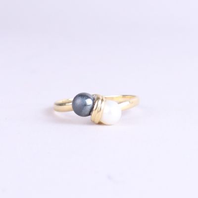 a close up of a gold ring with two pearls on it