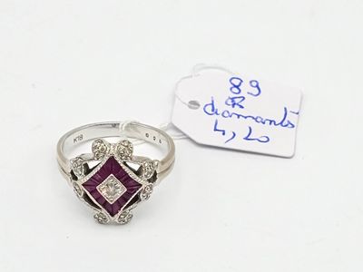 une photo d'une bague sertie d'un diamant et d'un rubis, avec une étiquette indiquant le prix