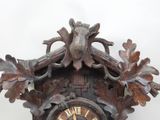 a wooden clock with a bird on the top of it