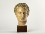 marble head of a man with curly hair on a wooden base