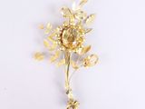 gold plated flower brooch with leaves and flowers on a white background