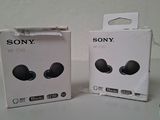 two boxes of sony earphones sitting next to each other on a table