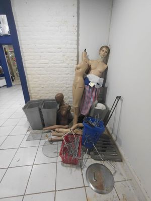 un mannequin dans un coin de la pièce, à côté d'une poubelle