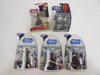 cinq figurines « Star Wars » sont alignées sur une table