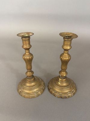 pair of antique brass candlesticks on a white background