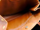 a brown leather bag sitting on a black surface