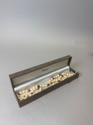 un gros plan d'une boîte contenant un collier de perles