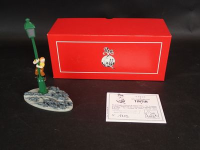 une petite figurine d'un homme debout à côté d'une boîte rouge