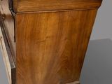 an old wooden cabinet with a marble top sitting on a gray surface