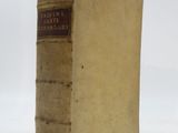 an old book sitting on top of a white table next to a white wall
