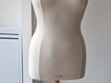 a mannequin on a wooden stand in a room